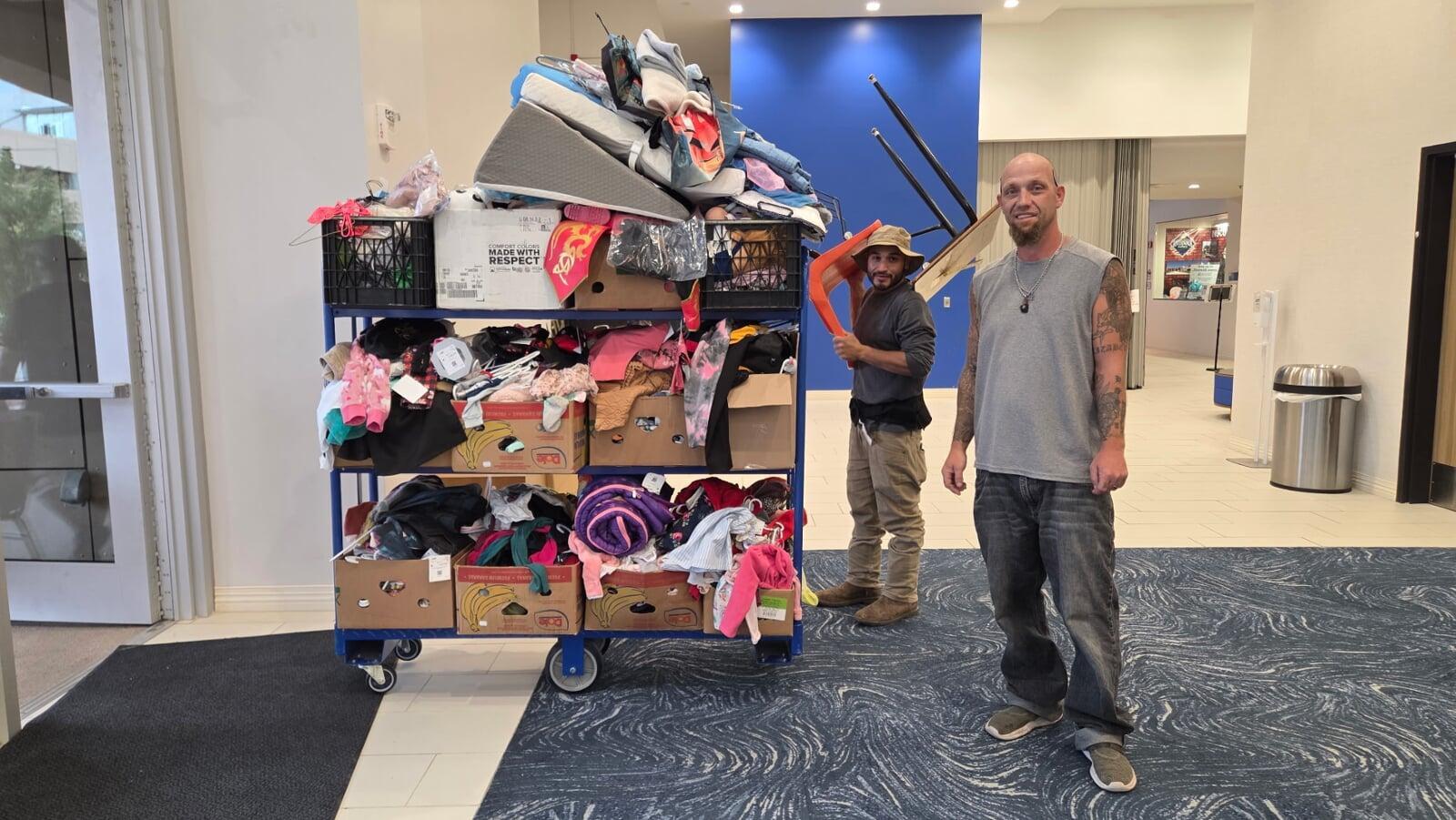 Two hands hold either side of a small, black paper cut out heart.